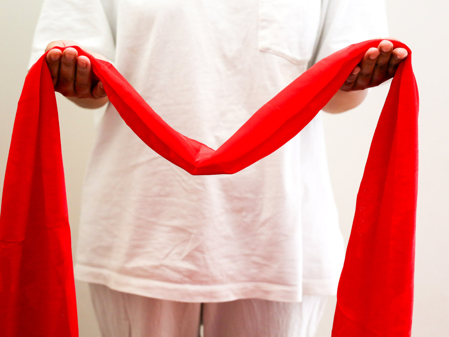 red khata scarf held in open hands