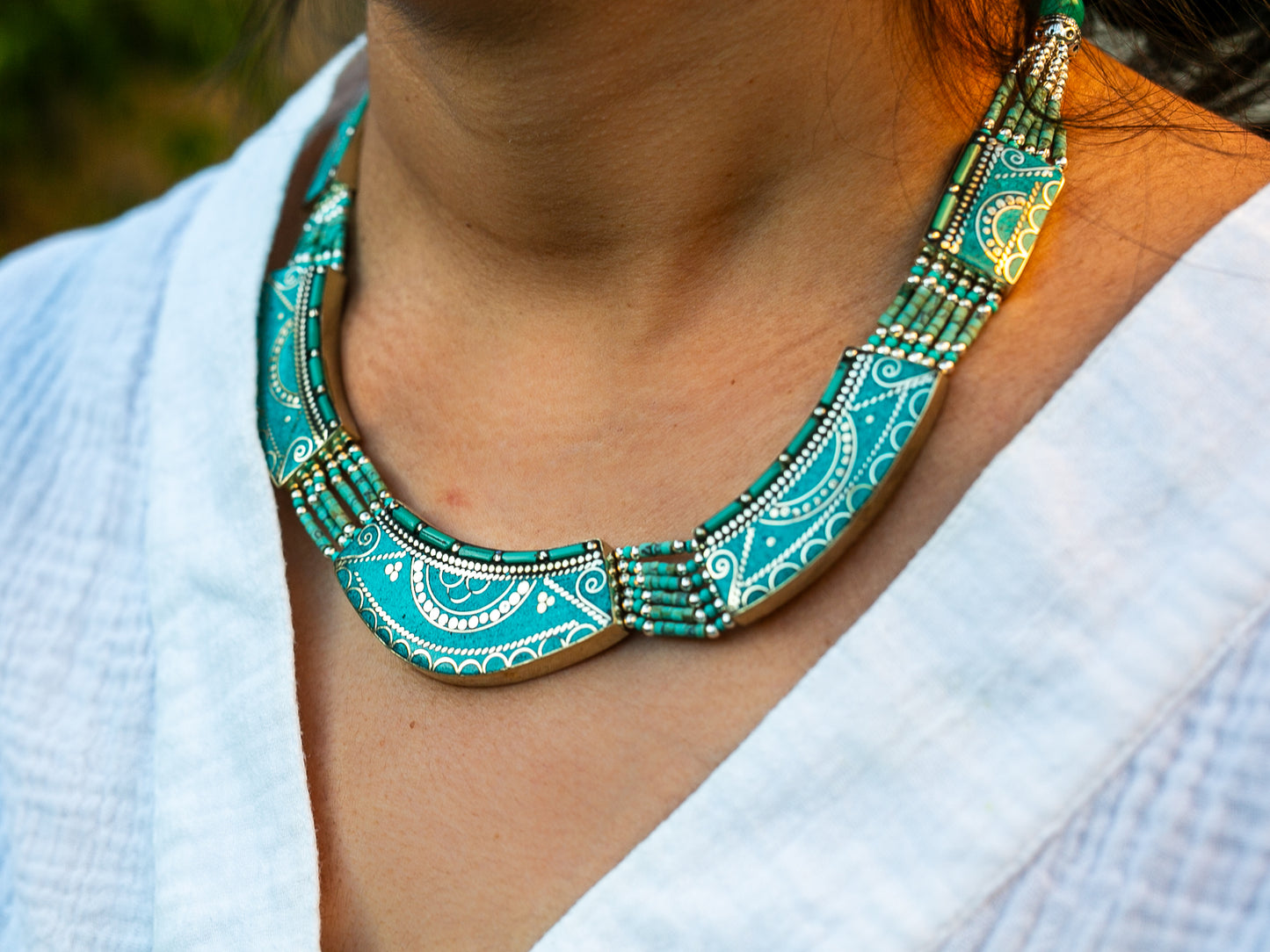 Turquoise necklace in Tibetan design worn around woman's neck