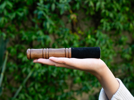 photo of small hardwood ringing stick on palm of hand