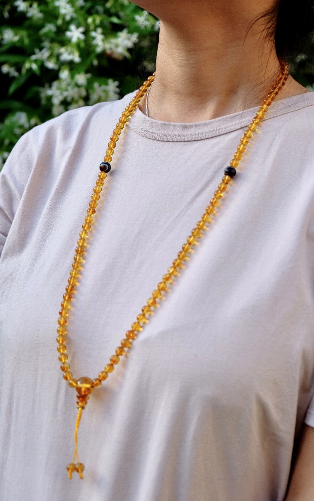 Another view of honey amber prayer beads worn around neck