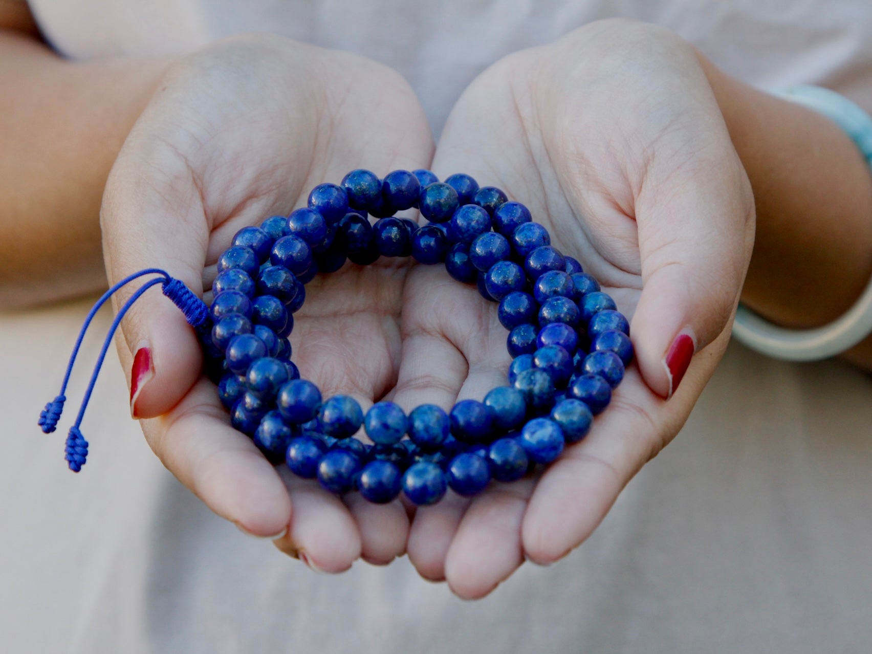 Lapis lazuli mala beads held in hand