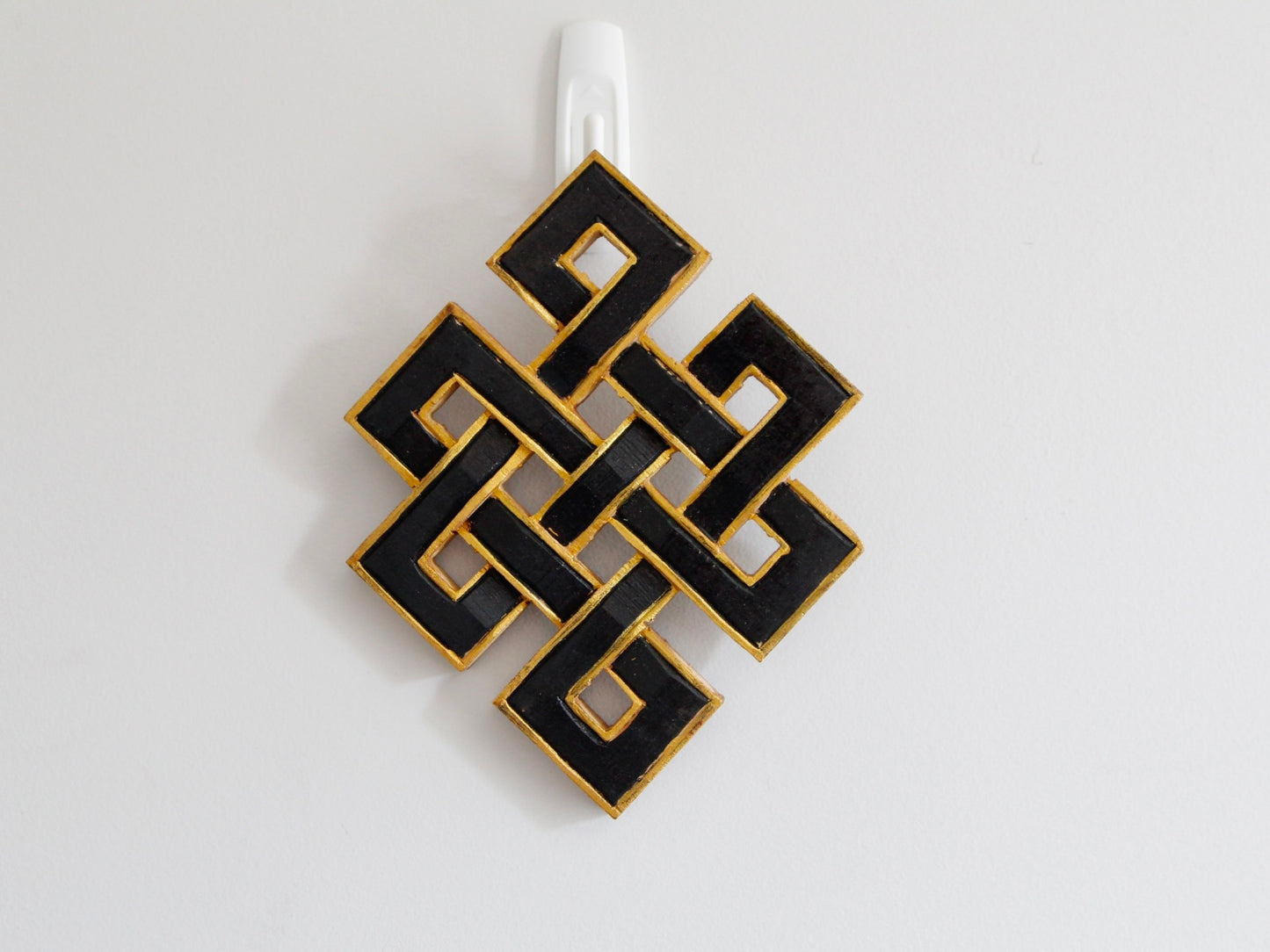 Infinity endless knots hanging up against wall: Black with golden border