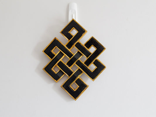 Infinity endless knots hanging up against wall: Black with golden border
