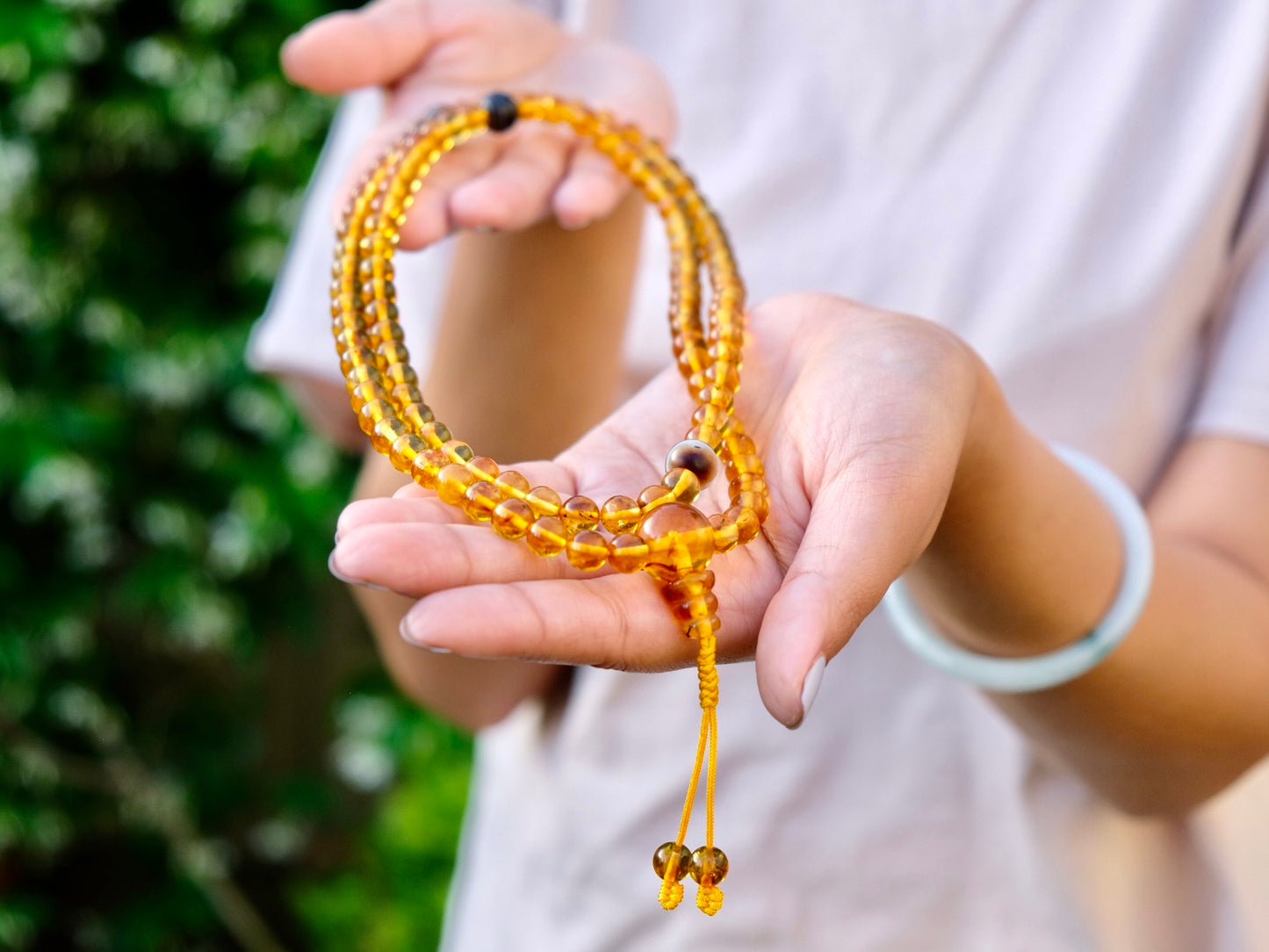 Honey Amber mala stretched on Kunga's hands.