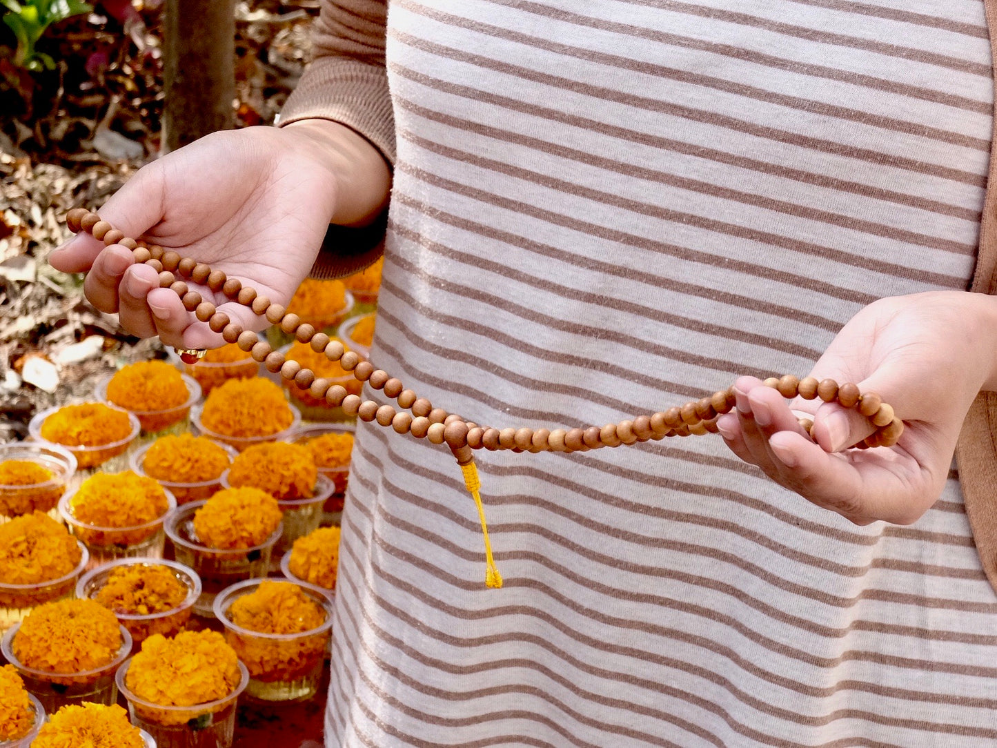 sandalwood mala beads being held wide