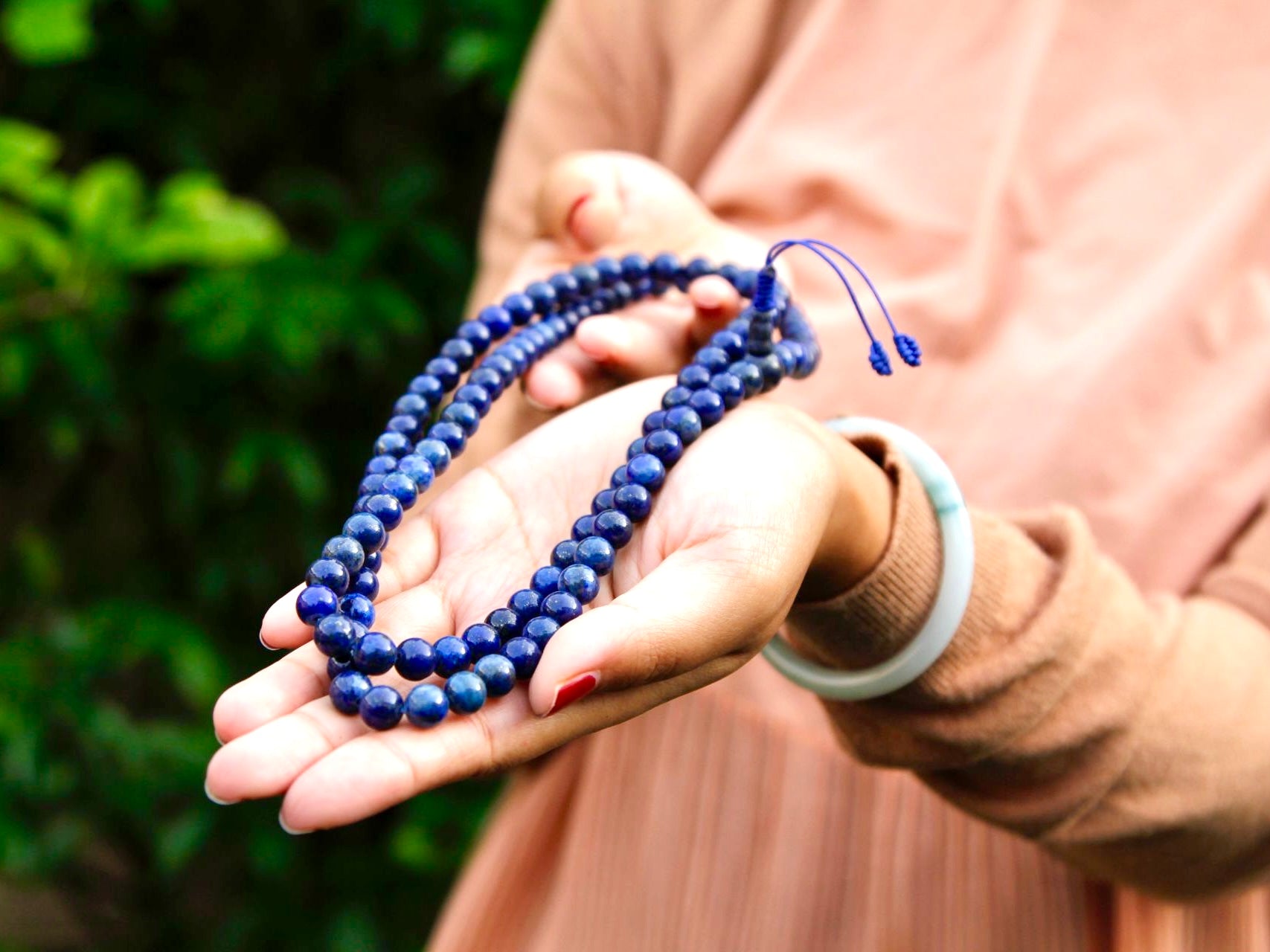 Lapis lazuli mala beads stretched out on hand showing colour