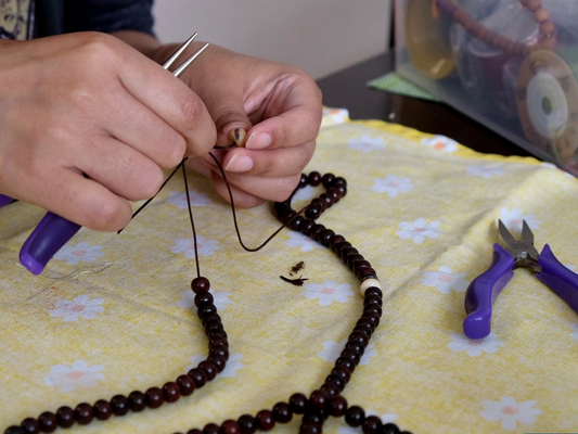 hands repairing mala beads