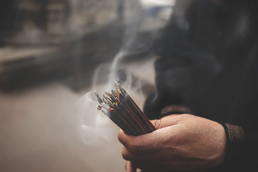 Tibetan incense sticks held in hand 