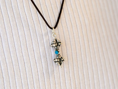 Necklace with a Dorjee Vajra pendant on a textured beige surface