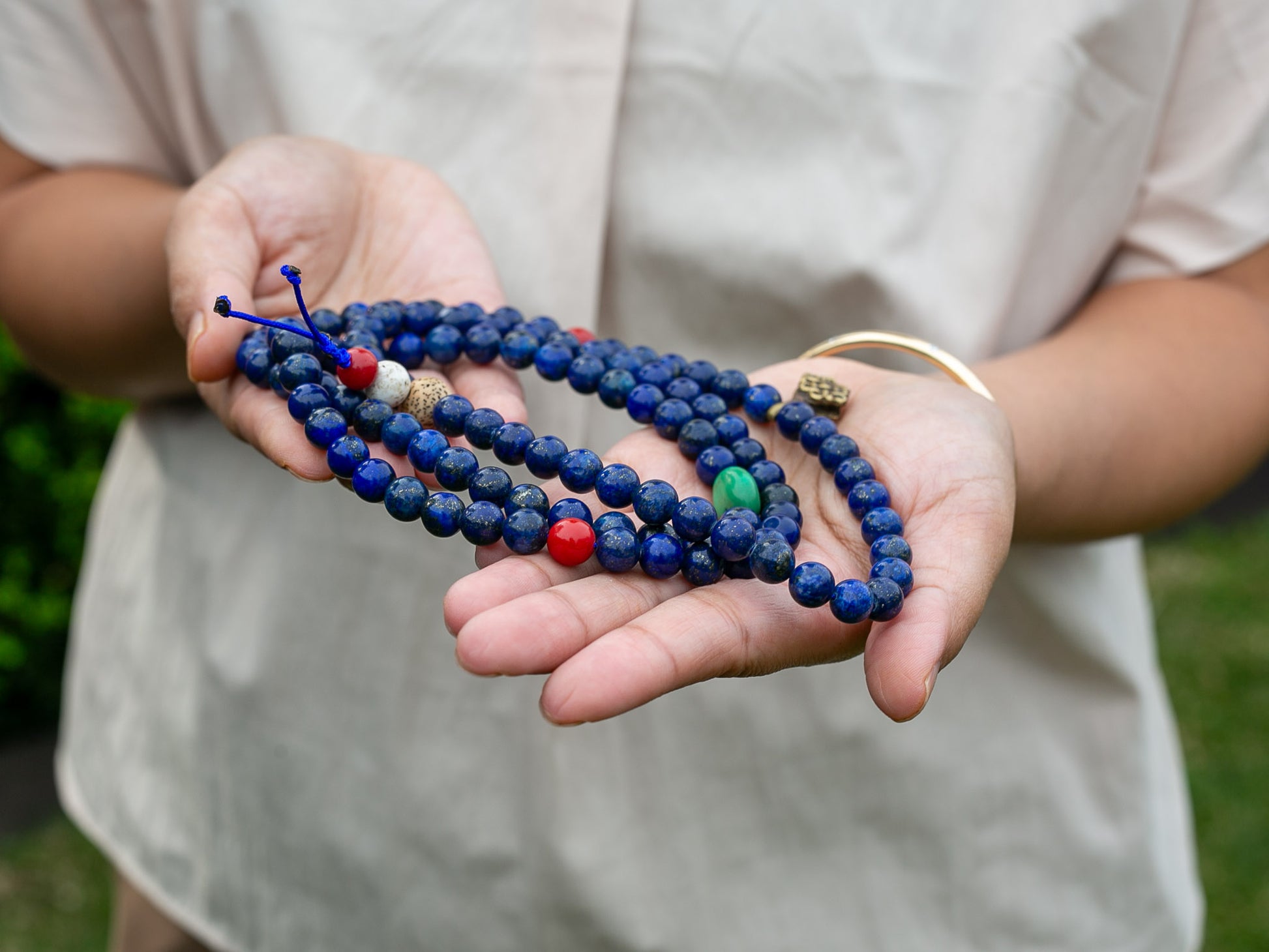 Lapis mala beads held in palm of hand