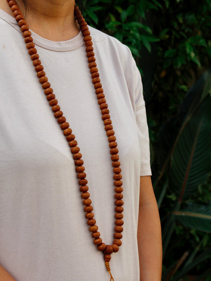 Side view showing Bodhi seed mala worn around neck