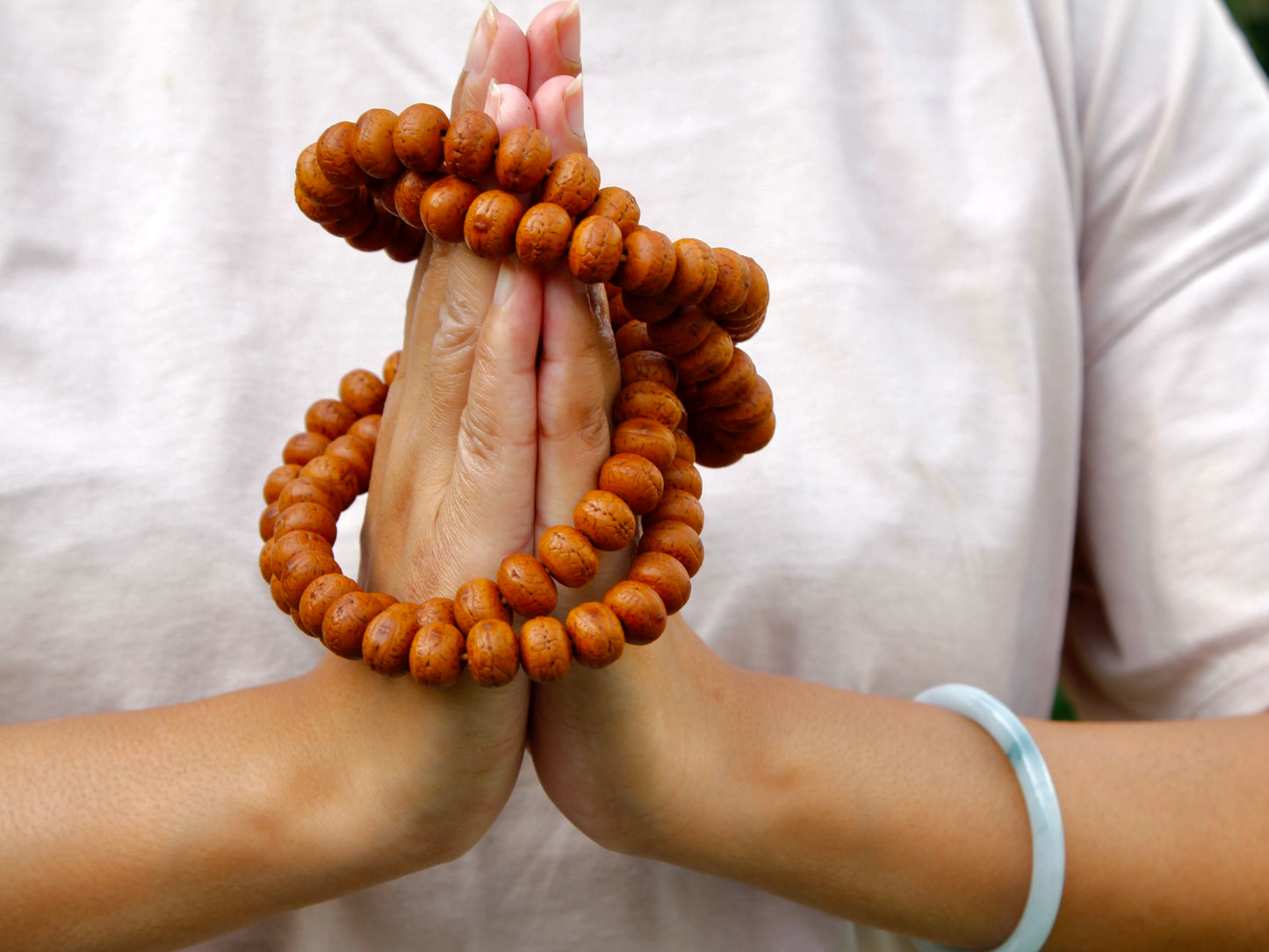 Long Bodhi mala wrapped around Namaste hands