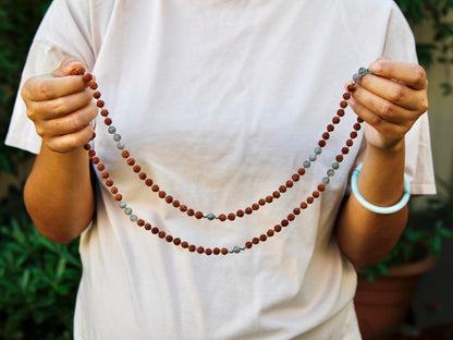 Rudraksha mala held between two hands in open hand gesture