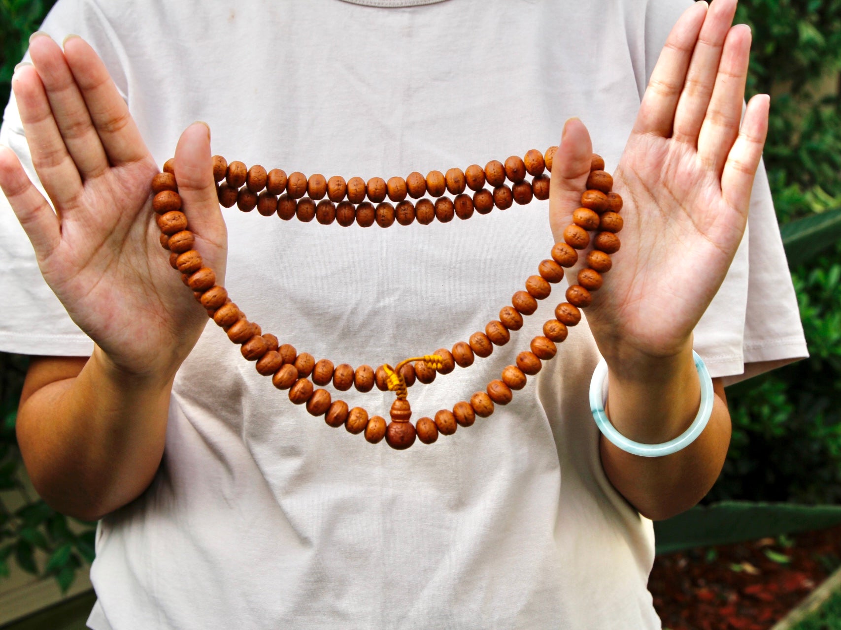 Long Bodhi seed mala with natural finish wrapped twice around hands