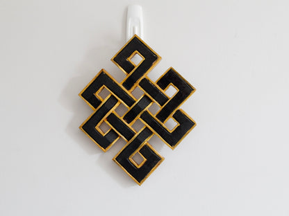Infinity endless knots hanging up against wall: Black with golden border  