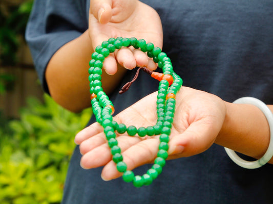 Green onyx mala with 108 beads held in Kunga's hands
