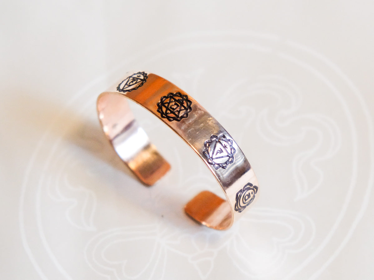 Copper bracelet viewed from top showing chakra engraving