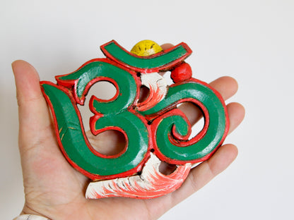 Om wooden wall hanging held in hand