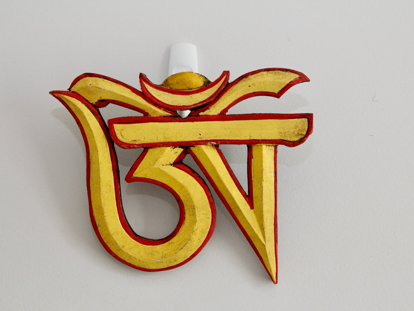 Tibetan Om wall hanging up on wall in yellow