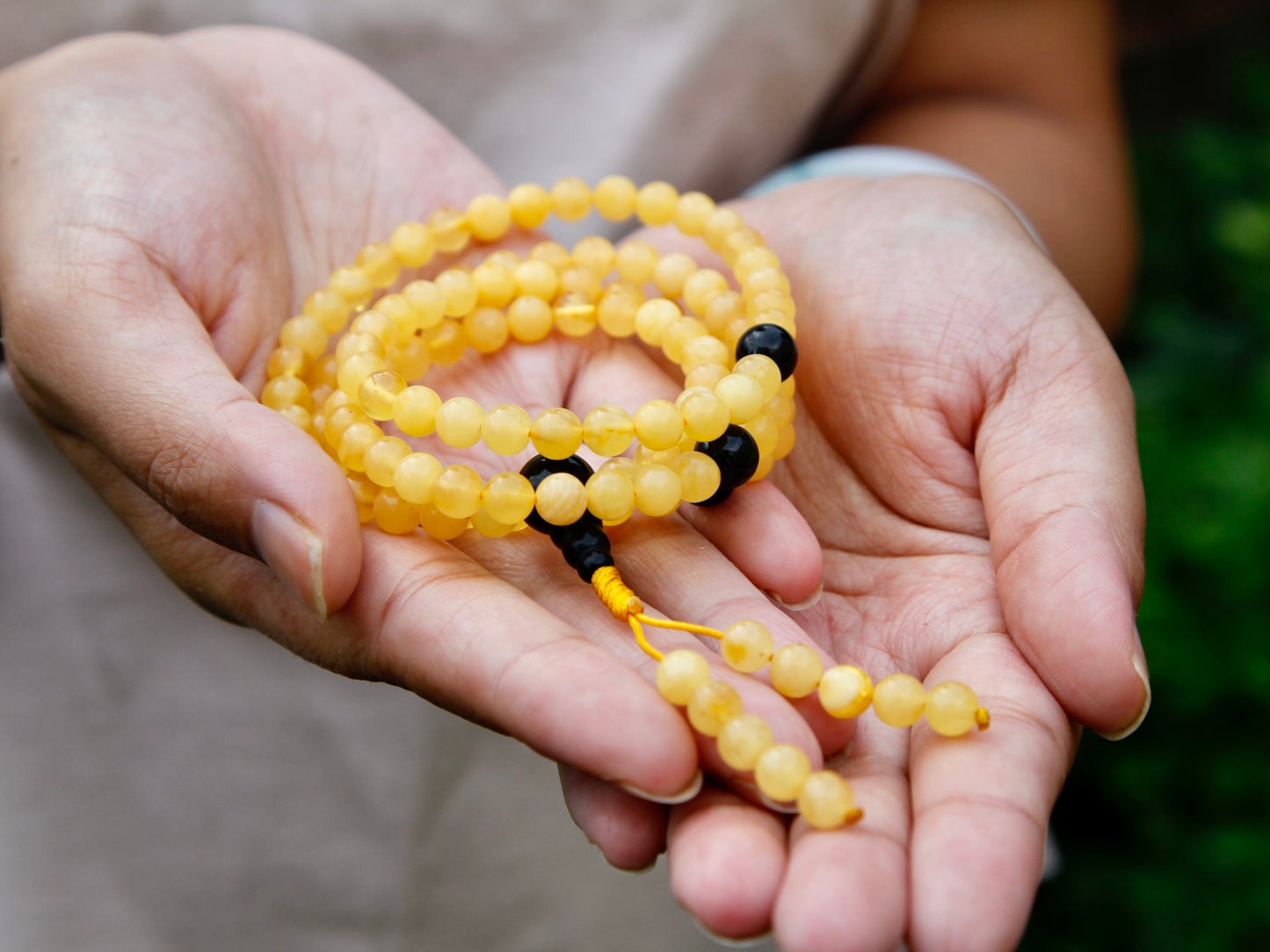 Close up of amber mala bead showing butterscotch yellow colour