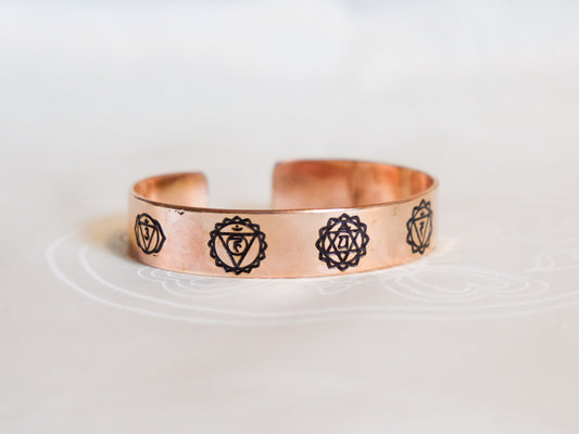 Pure copper bracelet showing chakra symbols against white background