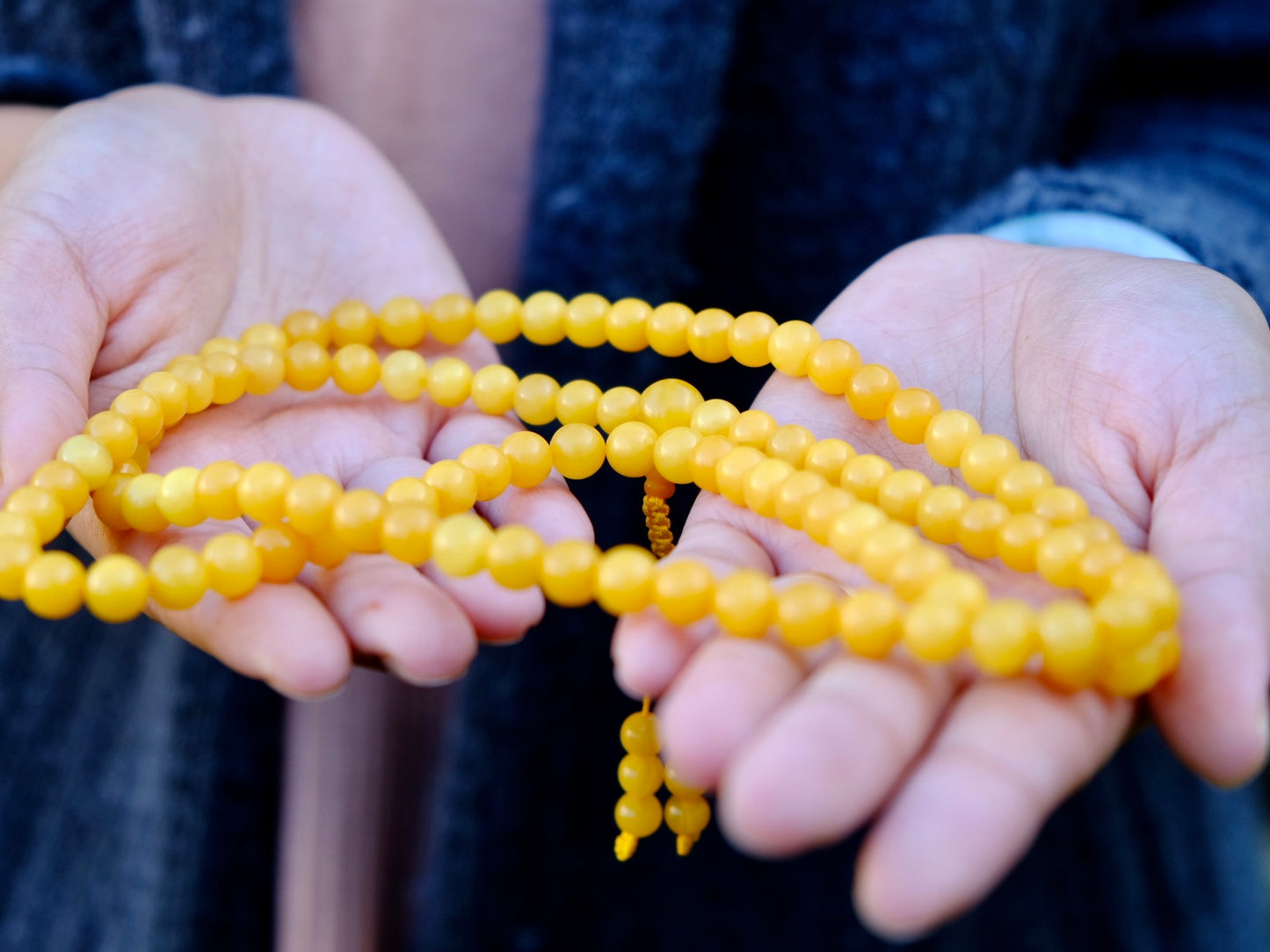 amber mala held on palms