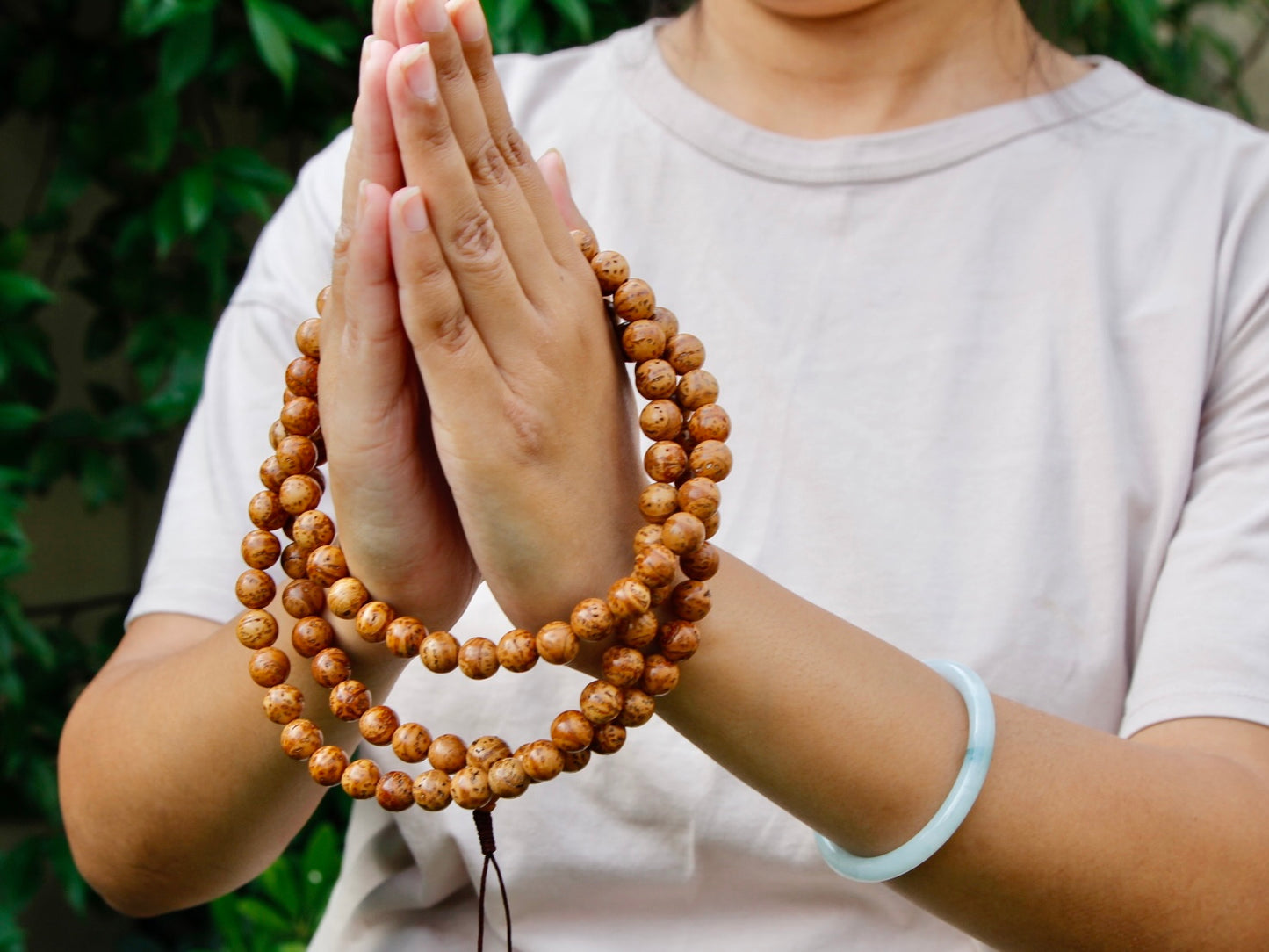 Bodh gaya bodhi mala wrapped in hands in Namaste gesture