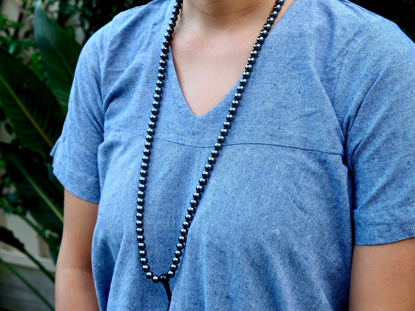 hematite mala beads worn around neck viewed from the side