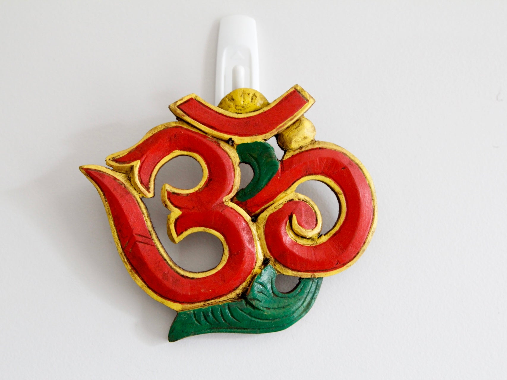 Red variant of Om wooden wall hanging