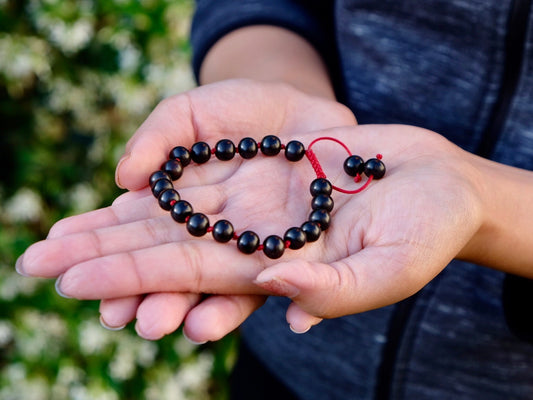 Knotted ebony wrist mala bracelet in Kunga's palm