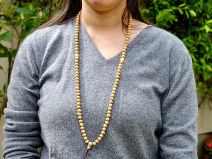 Lotus seed mala with amber spacer beads worn around neck