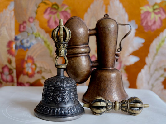 Tibetan bell and vajra set with copper case in front of brocade 