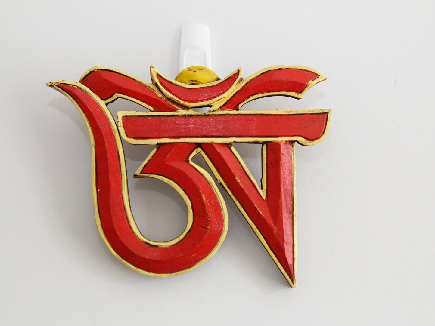 Tibetan Om wooden wall hanging up on wall