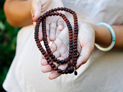 Rosewood mala beads 108 stretched out in palm 
