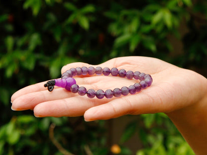 Amethyst mala bracelet held flat in palm 