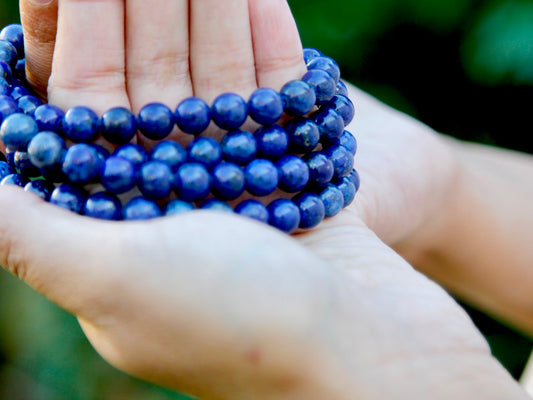 Lapis lazuli mala wrapped around hands 