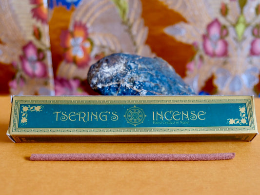 Packet of Tsering's Incense resting against rock