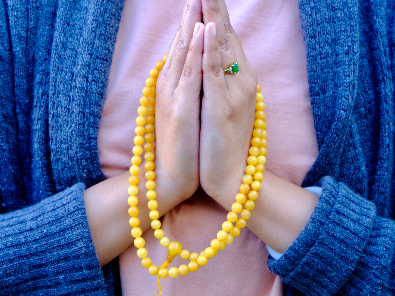 amber mala displayed on folded hands